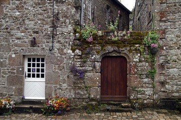 Doors in old medieval stone walls along a street in Locronan Bretagne 