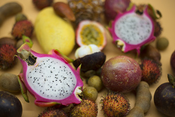 Fototapeta na wymiar Tropical fruits background, many colorful ripe tropical fruits