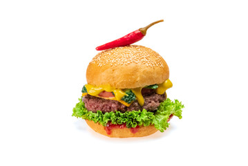 Tasty cheeseburger grilled cutlet, sesame bun,  tomato, onion, fresh lettuce and red chili peppers isolated on white background. Fastfood concept