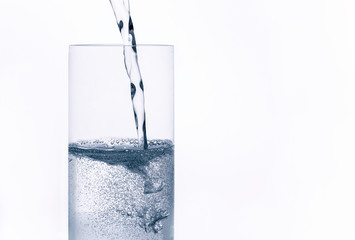 sparkling water with bubbles is poured into glass