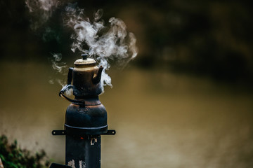 camping stove standing on the grass at the lake 