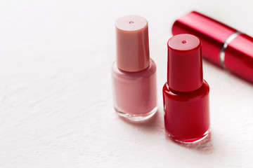 Nail polish and lipstick on a white background.