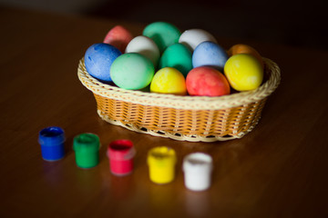Fototapeta na wymiar Easter eggs in wooden basket on dark background