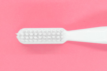 White toothbrush on pink background