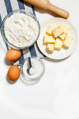 baking background with eggs, flour, sugar, butter and rolling pin on white background