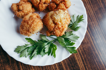 fried fresh cauliflower in breadcrumbs closeup on a plate.