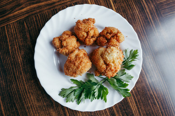 fried fresh cauliflower in breadcrumbs closeup on a plate.