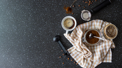 Składniki do przygotowania kawy leżące na czarnym stole