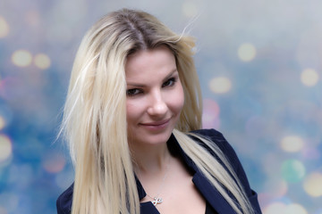 Naklejka premium Portrait of happy smiling young cheerful businesswoman standing with flowing hair. Success in business concept studio shot. Blue suit. Multicolor wall background.