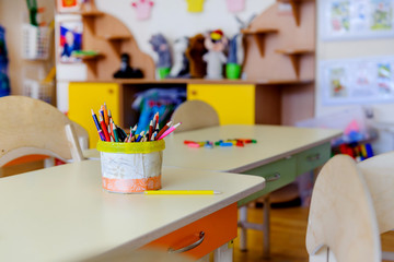 On the tables in the children's playroom are colored pencils.