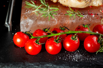 Pieces of roast beef with spices served on black slate.