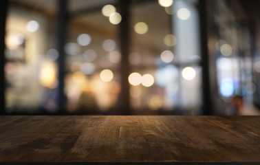 Empty dark wooden table in front of abstract blurred bokeh background of restaurant . can be used...