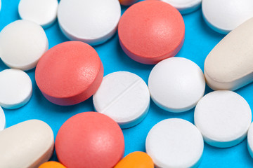 Obraz premium set of multi-colored tablets and capsules on a blue background