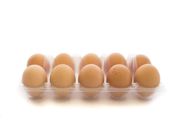 Close-up view of raw chicken eggs in transparent egg box  isolated on white background.