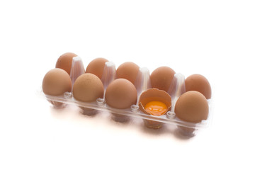 Close-up view of raw chicken eggs in transparent egg box  isolated on white background.