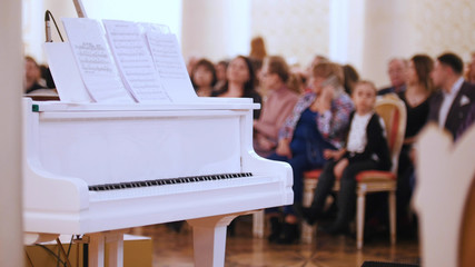 A jazz concert in the concert hall. Piano on the foreground and audience on a background