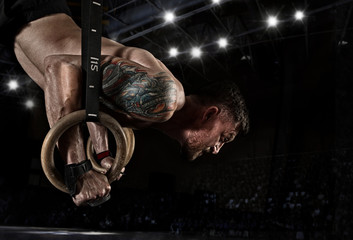 Muscular man pulling up on a gymnastic rings
