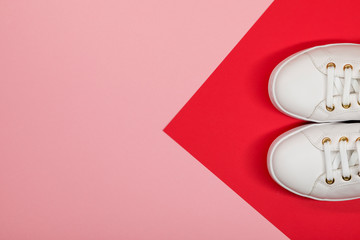 White sneakers on red and pink background. Flat lay