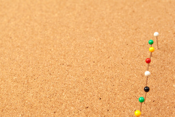 Group of thumbtacks pinned on corkboard