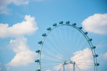Ferrist wheel with beautiful blue sky in day light in amusement park in Singapore.