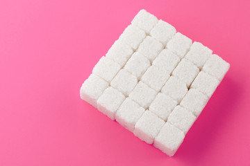 Cubes of sugar on a pink background. Empty space for copying text