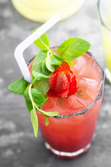 Strawberry drink with mint, ice cubes and straw close up