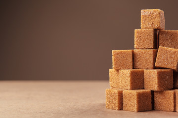 Brown cane sugar cubes on a light brown background