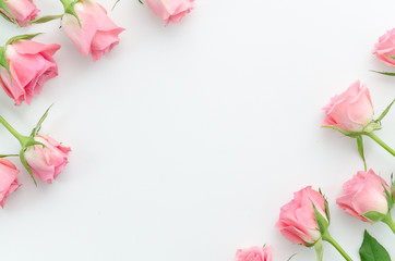 Floral pattern, frame made of beautiful pink roses on white background. Flat lay, top view. Valentine's background. Floral frame. Frame of flowers. Flowers texture