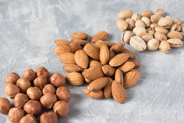 mixed nuts on a gray background. Walnut, pistachios, almonds, hazelnuts and cashews, walnut.