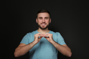 Man using sign language on black background