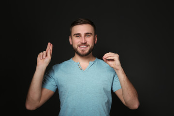 Man using sign language on black background