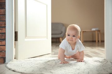 Fototapeta premium Cute little baby crawling on rug indoors, space for text