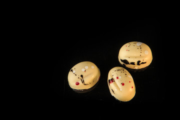 closeup top view of three small oval-shaped white chocolate candies
