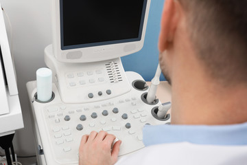 Fototapeta na wymiar Sonographer operating modern ultrasound machine in clinic, closeup
