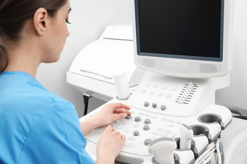 Fototapeta na wymiar Sonographer operating modern ultrasound machine in clinic