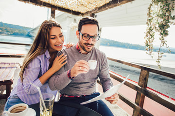 Young cheerful man and woman dating and spending time together in cafe