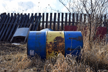 Iron water barrel.Wooden fence. Suburban area.