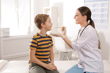 Doctor examining adorable child in hospital office