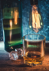 A glass of whisky on rough wooden background