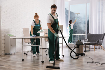 Fototapeta na wymiar Team of professional janitors working in modern office. Cleaning service