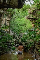 boy back to the landscape, man relaxing in the landscape, young boy exploring the landscape of rocks, river and trees