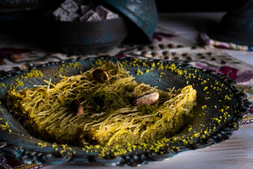 Traditional Arabic/ Turkish dessert baklava with pistachios, and tea, turkish delight dark background with authentic decoration