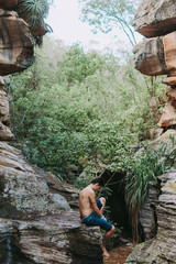 boy back to the landscape, man relaxing in the landscape, young boy exploring the landscape of rocks, river and trees