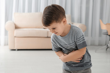 Little boy suffering from nausea in living room