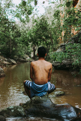 boy back to the landscape, man relaxing in the landscape, young boy exploring the landscape of rocks, river and trees