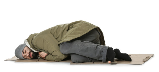 Poor homeless man lying on cardboard, white background