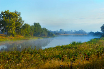 Fog or haze over the lake on a summer morning. Beautiful countryside