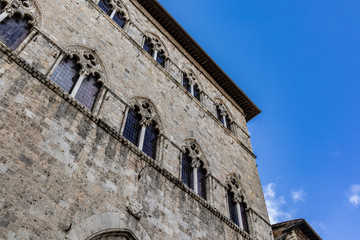 Fototapeta na wymiar Old Italian ancient building facade on a diagonal bottom composition on a solid blue sky
