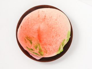 Top view of longevity peach on wooden plate isolated on white background. Chinese specialty pastry.
