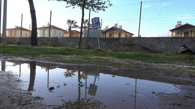 4K Puddle and paking sign reflected in it